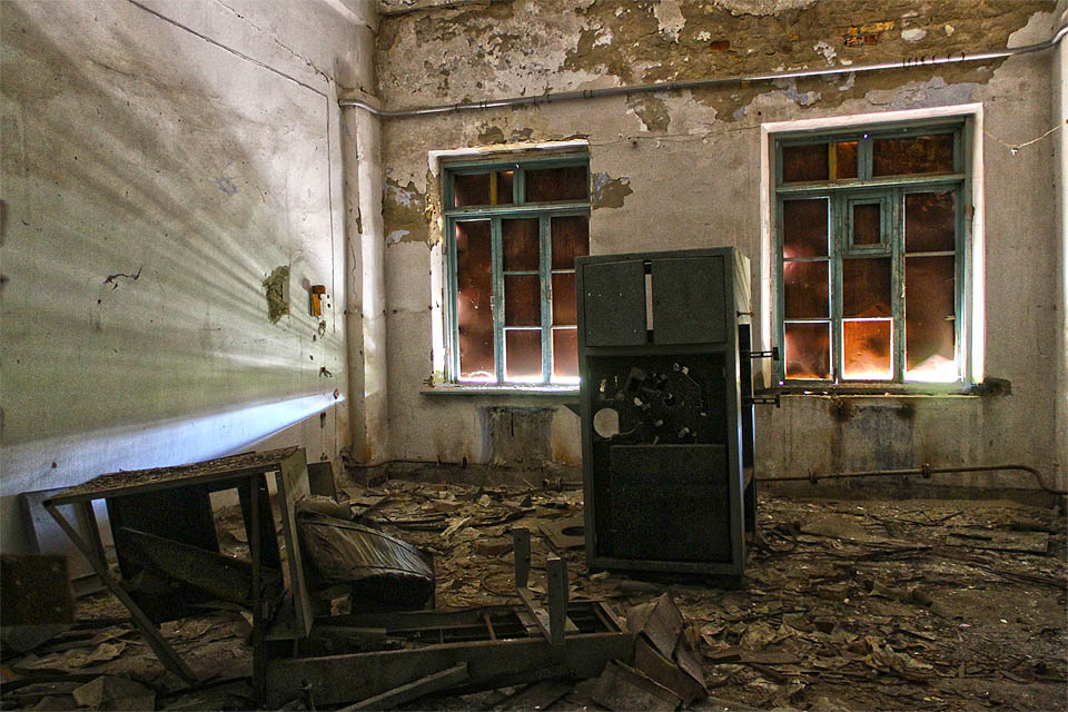 Okna kdosi před léty zatloukl plechem a dodal tak ponuré temné místnosti s neznámým strojem děsivý nádech.