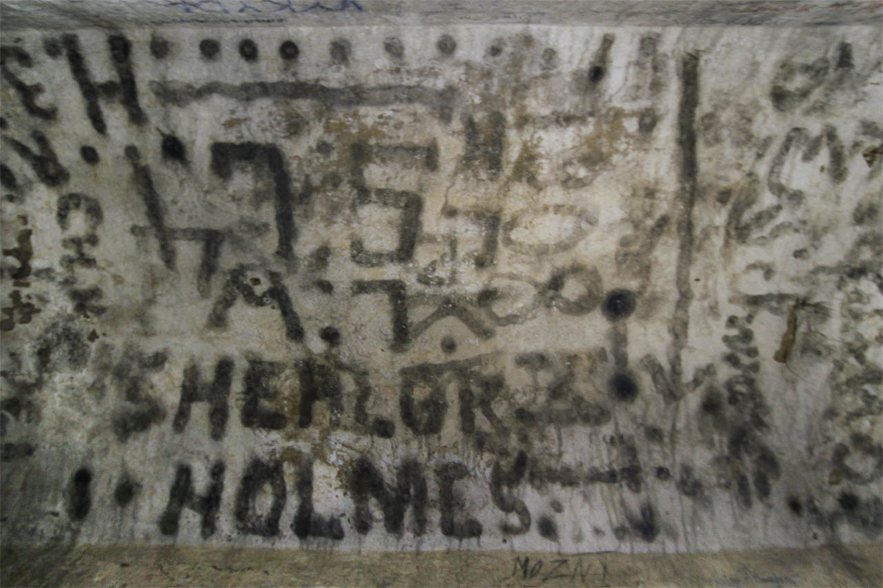 Předchůdci dnešních sprejerů zřejmě za 1. světové války pomalovali stropy chodeb plamenem hořící svíčky. Přestože lze dým snadno setřít prstem, přežily tu nápisy celé století. A Sherlock Holmes byl v kurzu už tenkrát. Letopočet 1808 je ale zřejmě spíš vtipem než skutečností.