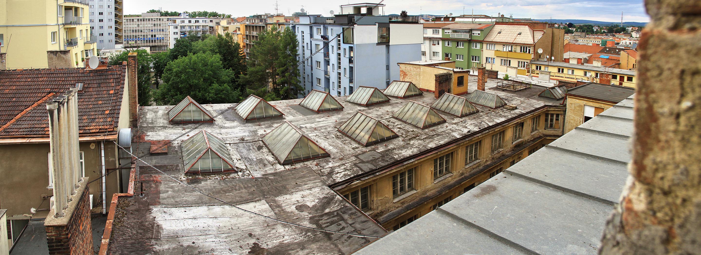 Z nejvyššího patra hlavní budovy je impozantní výhled do dvorních traktů Mášovy ulice, na hotel Continental (schodiště vlevo nahoře) a dokonce i na komín <a href=/Tema/Cement%C3%A1rna%20Malom%C4%9B%C5%99ice>maloměřické cementárny</a>.