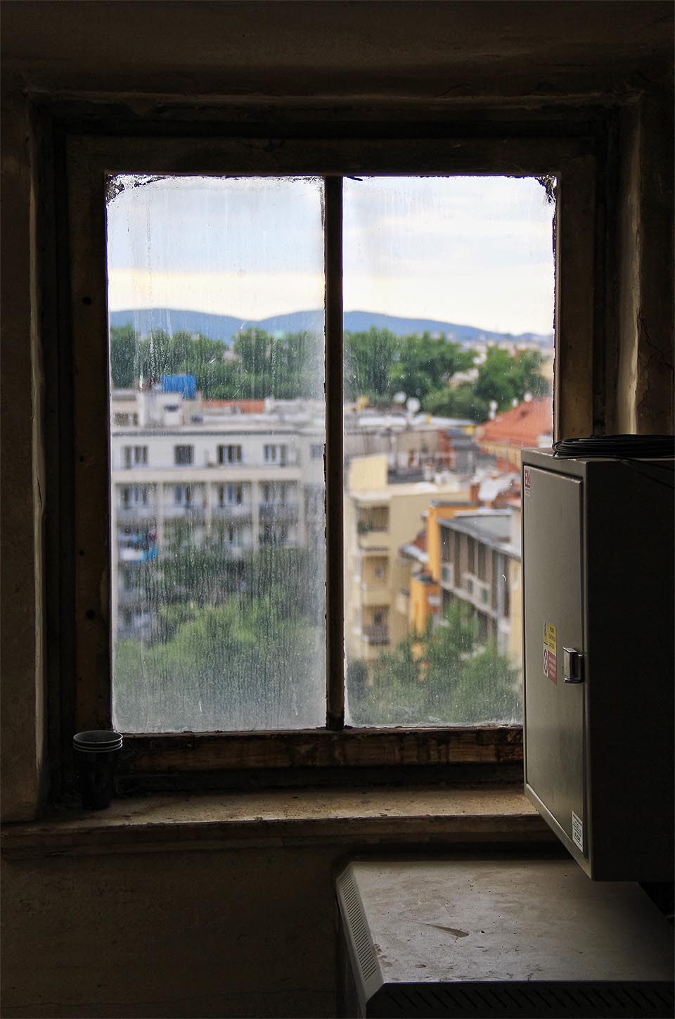 Komůrka za strojovnou výtahu s výhledem na dvory prvorepublikových domů na Mášově ulici.