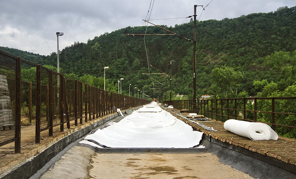 Nezvykle bělostný pohled na útroby železniční trati. Na Most inteligence právě pokládají ochrannou textilii.