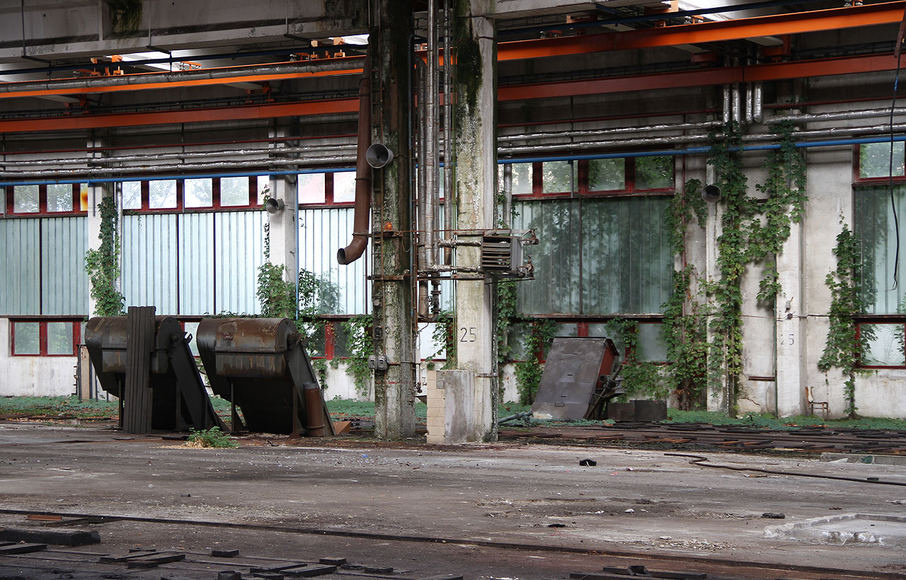 Není nám docela jasné, jak fungovala zakončení výrobních linek ve tvaru kovových křesílek. Podlaha je ale převážně kovová a tušíme, že se celé její části posouvaly napříč halou a motory na nich.