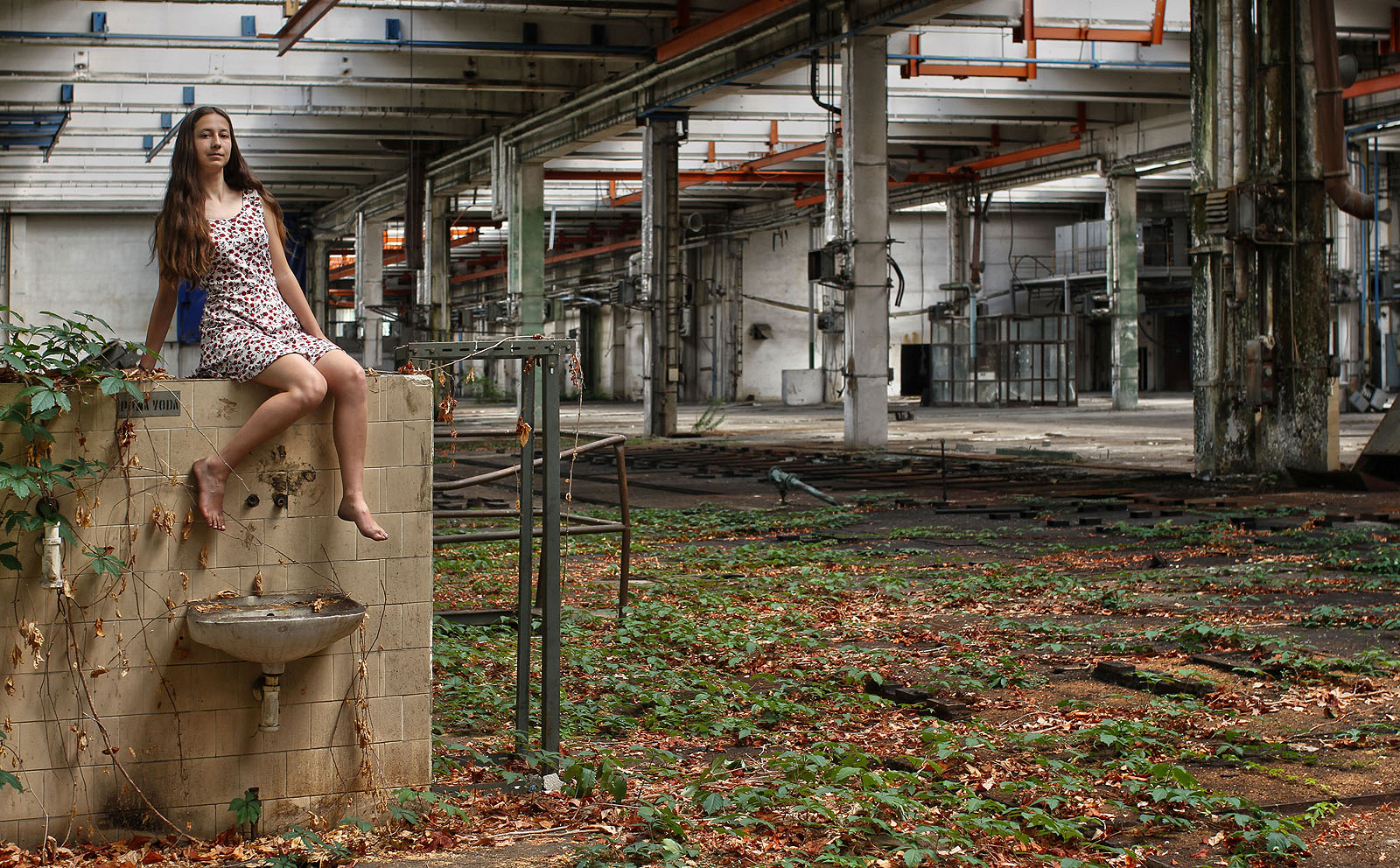 Odvážná školačka jako soška víly v dávno opuštěné letní zahradě.