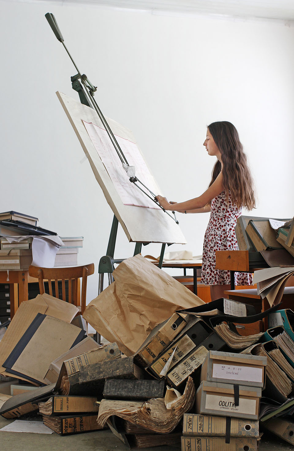 Za umývárnou se konečně dostáváme ke kancelářím. Výkres víka motoru tu právě dokončuje sličná konstruktérka z projekčního oddělení.