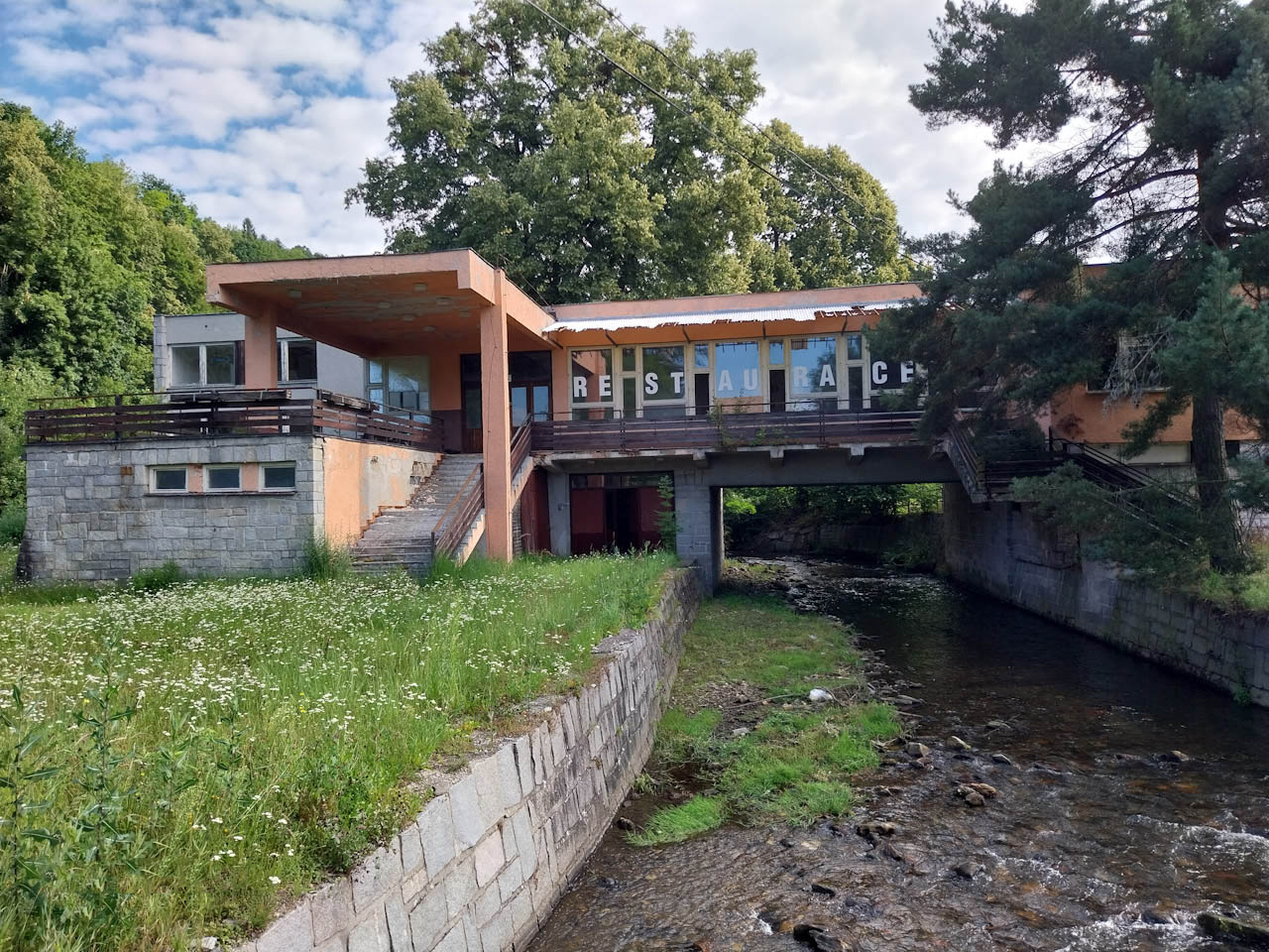 Celkový pohled na hlavní budovu. Na vyjímečnosti místa neubírá ani podtékající řeka Merta.