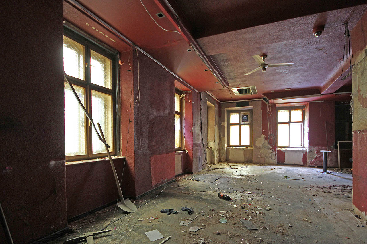 Z otvoru ve stropě vedoucího do vyšších pater čněla k odlaze lesklá taneční tyč. Skrze bylo možno pozorovat show z výše položené kanceláře.