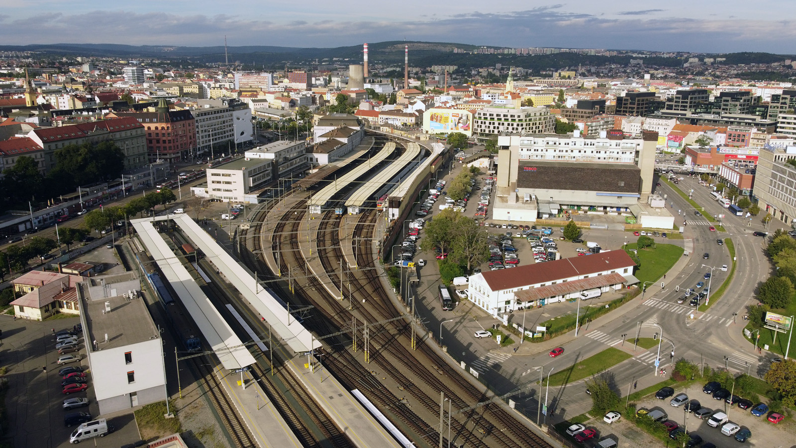 Letecký pohled na prostor <a href="/Tema/Brno hlavní nádraží (žst)">hlavního nádraží</a> včetně nádražní pošty (vlevo) a obchodního domu Tesco na sklonku léta 2023 kdy společnost Crestyl poprvé zveřejnila záměr budovu zdemolovat.