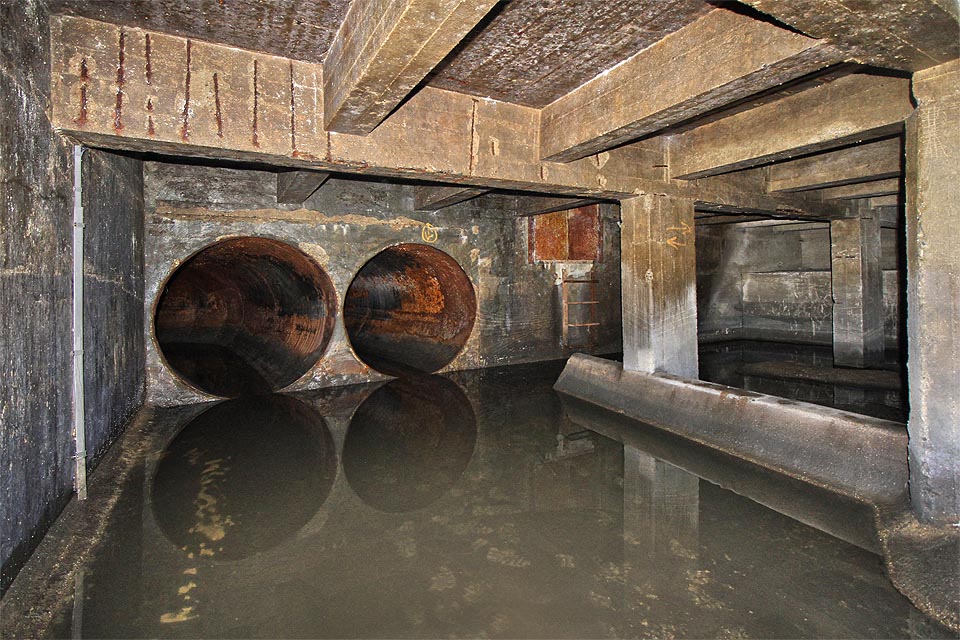 Nakonec se dostáváme do tajemného sálu. Povrch už není daleko, ocelová dvířka jsou ale důkladně uzamčena. Pod <a href=/tema/Zetor>strojírnu Zetor</a> vedou dvě ocelové roury. Je tu absolutní ticho, v neznámu, metry pod zemí.