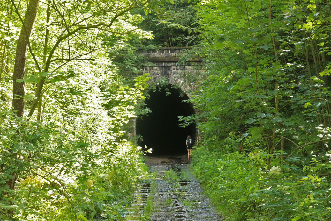 Nádherná železniční stavba je utopená v zeleni. Koleje od portálu pozvolna klesají k opuštěnému dolu PW Nikiel a dále na zrušené nádraží Kowary Górne.