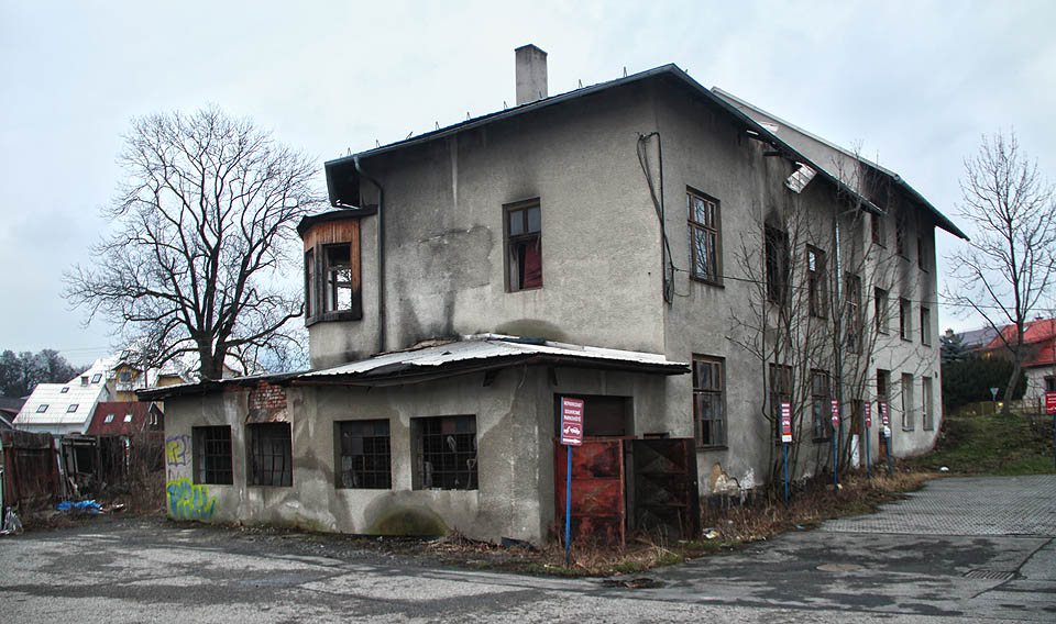 Pohled na Paláčkův mlýn od západu. Podél zadní levé stěny protékaly přes 400 let vody náhonu, který zkrášloval vzhled <a href="/Tema/Rožnov pod Radhoštěm">Rožnova</a> a dodával městu romantickou atmosféru. Za socializmu byl ovšem zasypán.
