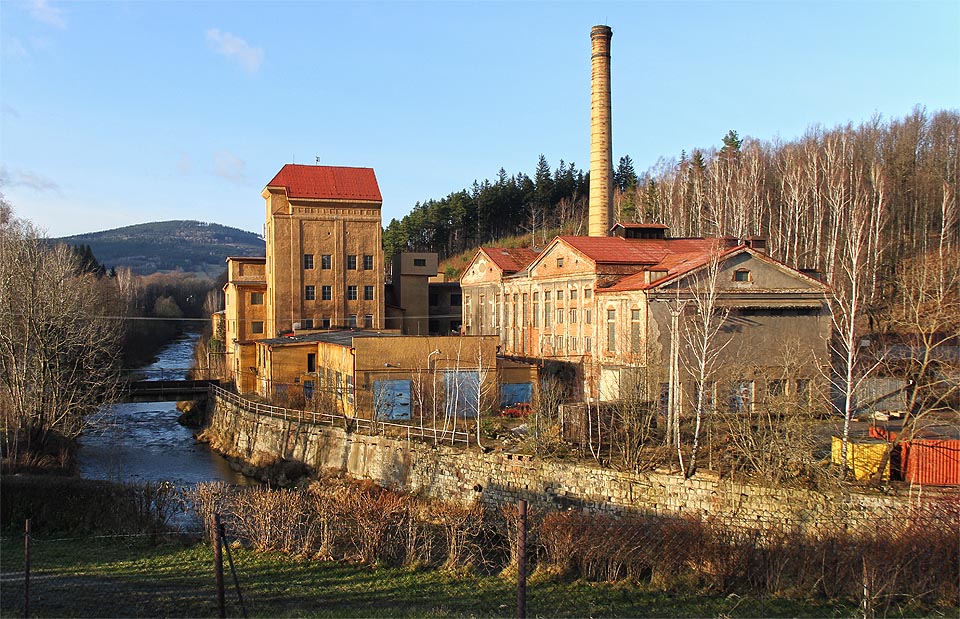 Továrna se přimyká k levému břehu řeky Bělé od roku 1845.