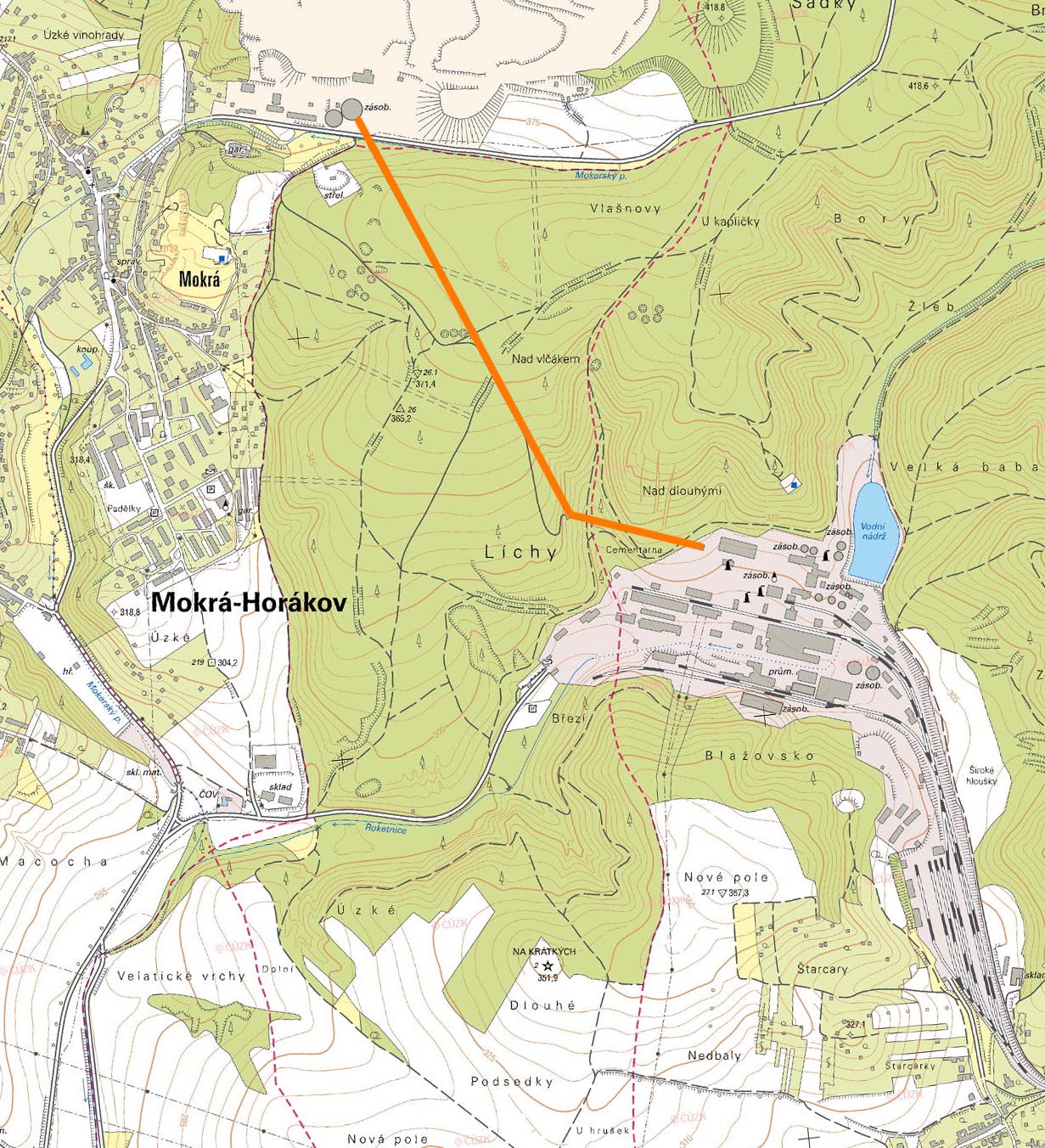 Oranžovou čarou je vyznačen pásový dopravník ze zásobníku vápence na kraji velkolomu (na severu), přes hřbítek kopce až k přesýpací stanici č. 2, kde se téměř kolmo lomí a zatáčí k východu přes dvojici mostů do areálu cementárny a vápenky.