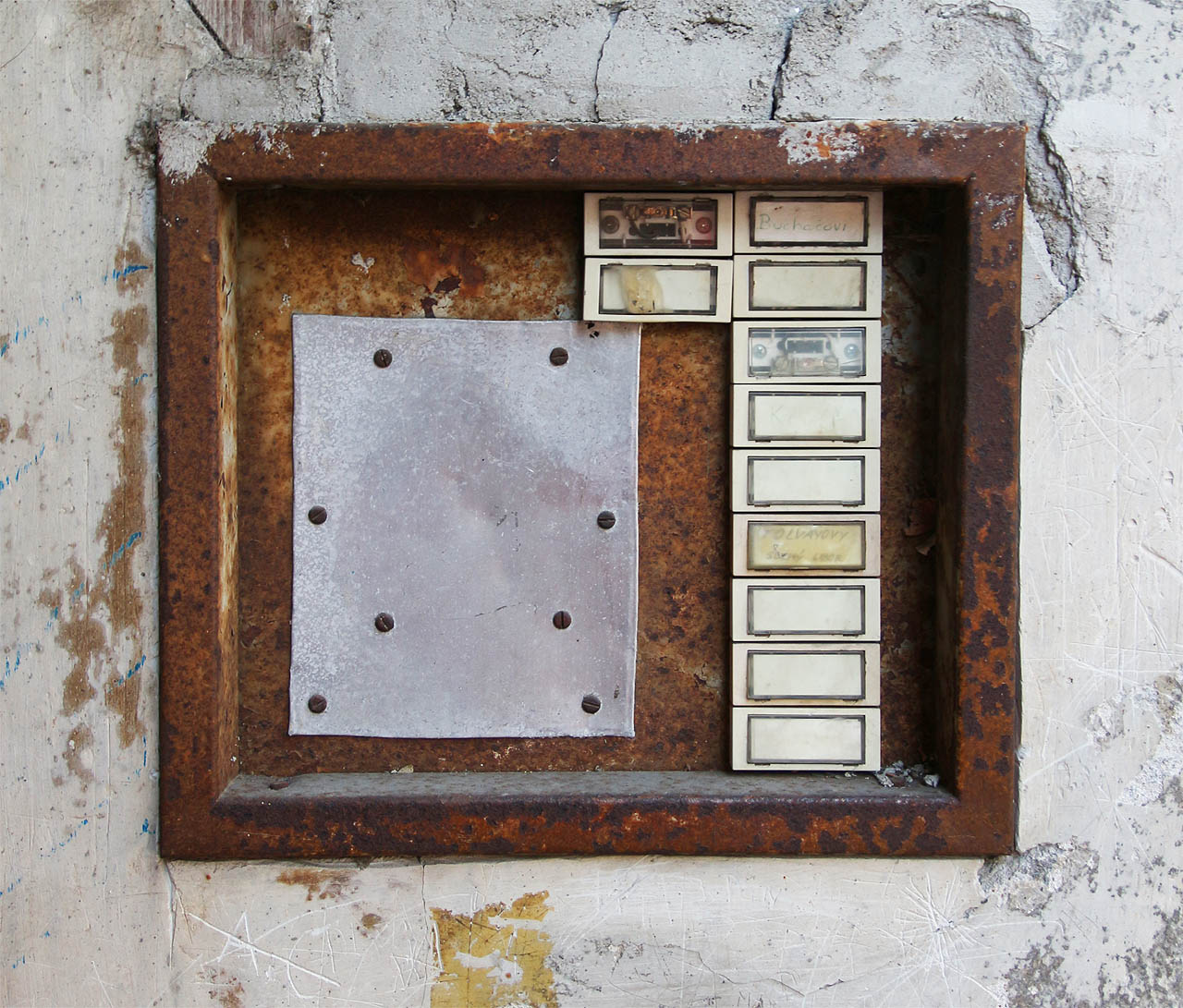 Soudě dle zvonků, nacházelo se v tomto domě původně 11 bytů a nebytových prostor. Jejich nájemníci se až na světlé výjimky příliš nezatěžovali tím, uvádět svá ctěná jména. Většinou se tu stejně nezdržovali na moc dlouho. Za opravu domovního telefonu kusem plechu by se na bytovém odboru mohl někdo snad i stydět.