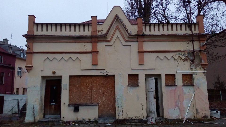 Vlevo od vstupní brány se nachází malá budova se zajímavou architekturou, která kdysi sloužila jako vrátnice, teď pouze jako stojan na lyže.