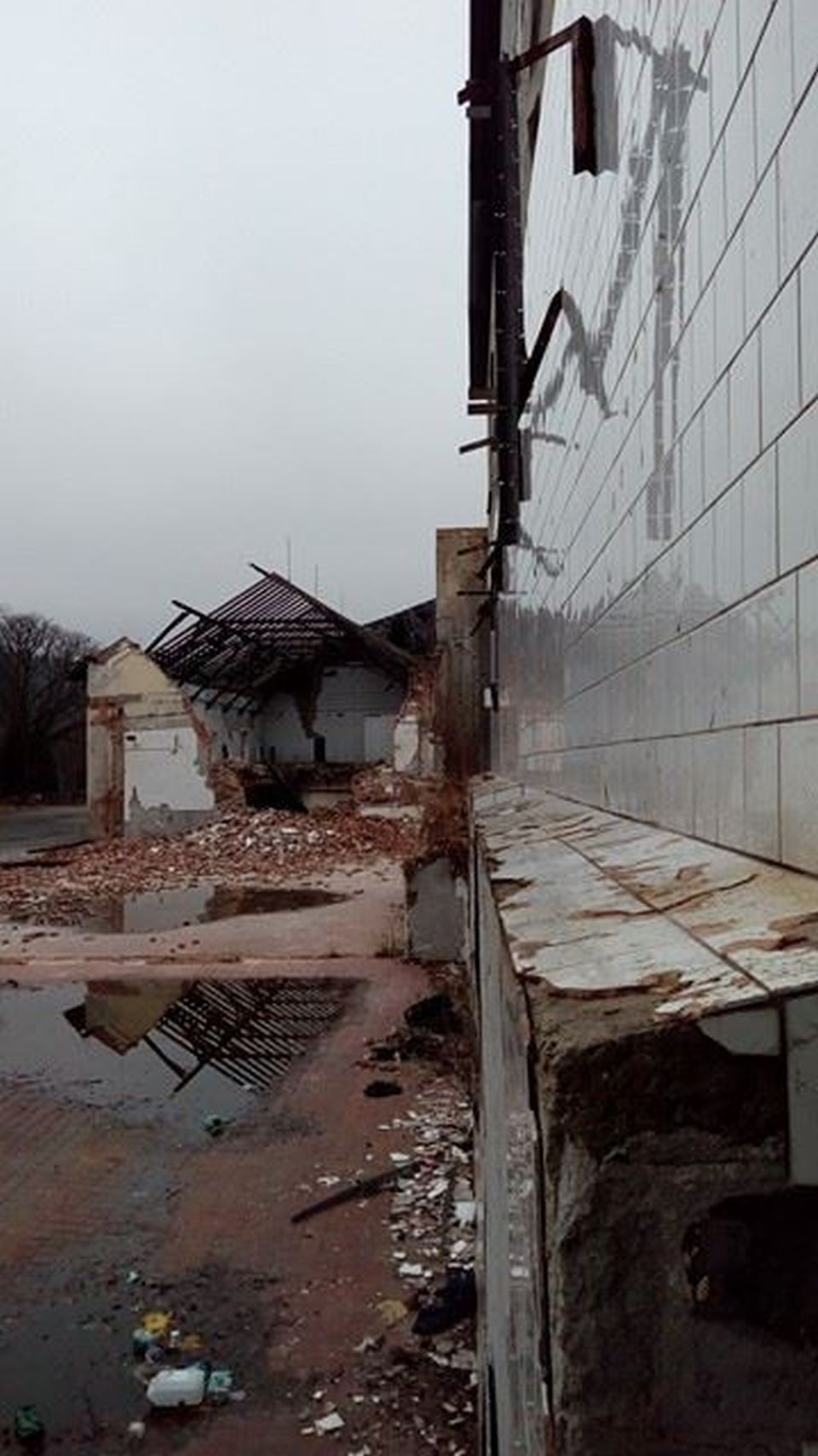 Podél vydlaždičkované zdi pokračuje k většině stojících budov.