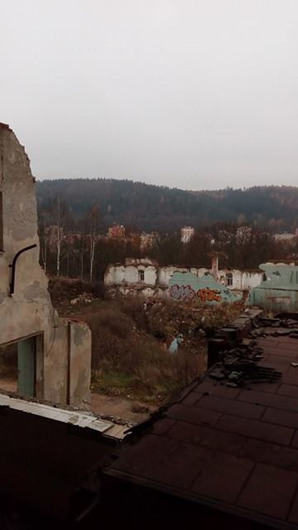 Otevírá se nám výhled na místo, které celé zaujímala jedna velká budova, z ní teď můžeme vidět jen obvodovou zeď v pozadí a propadající se strop sklepení.