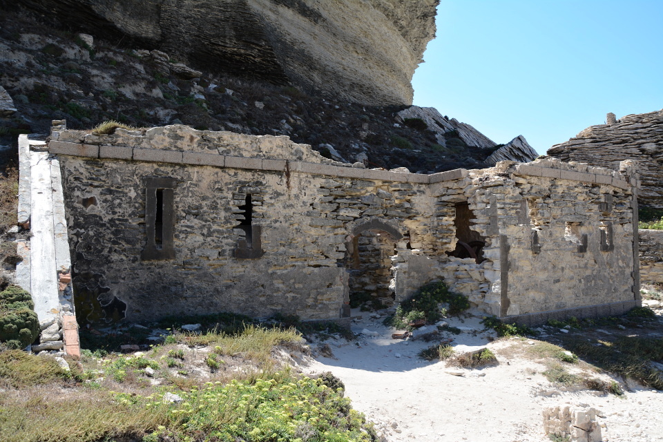 Pod útesy, téměř u pláže, těžko přístupný po strmé stezce stojí kamenný dům. Nebo alespoň to, co z něj zbylo.