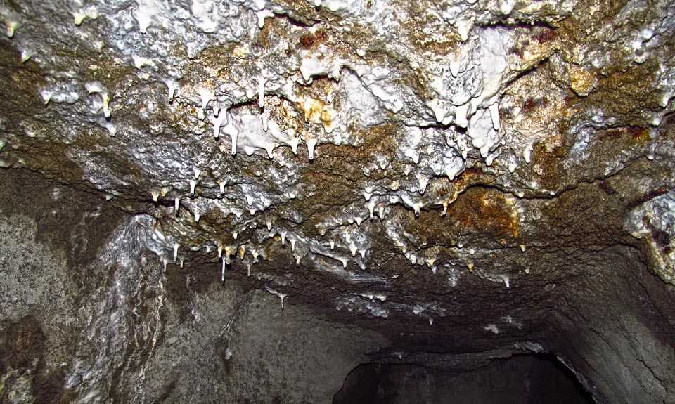 V krápníkovém sále prosakující vody vyplavují z betonové vrstvy bílý sintr.