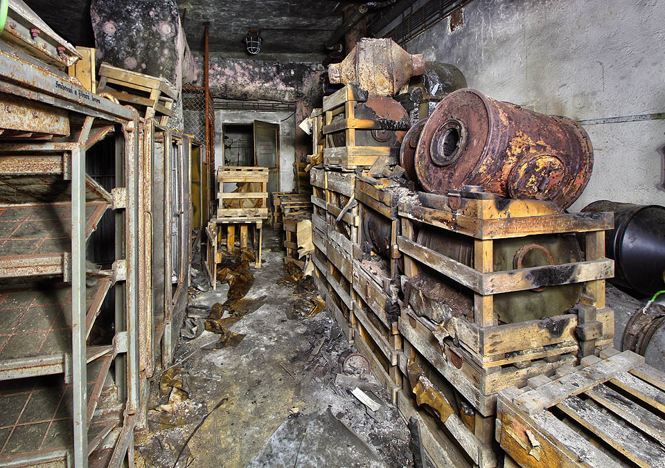 Vlevo jsou jednotlivá zařízení pro filtraci, vpravo zásoby rezivějících prachových filtrů.