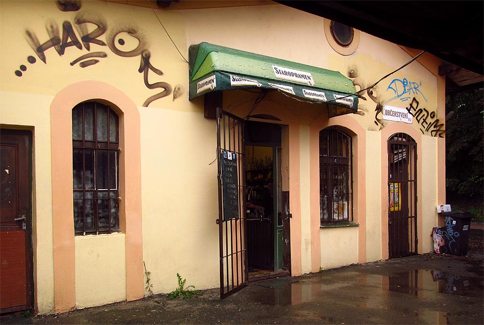 Nádražní restaurace ještě po nějakou dobu přežila ukončení provozu. V sále je zhasnuto, za výčepem ale pořád stojí vrchní…