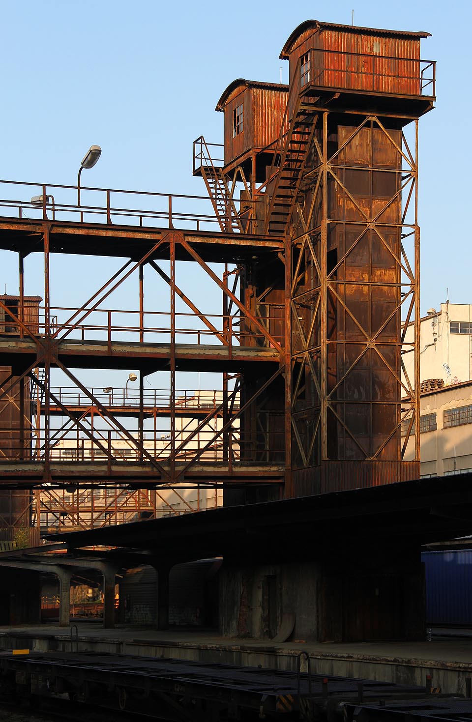 Rezivějící věže výtahových šachet jsou jako navždy spjatí blíženci, pevně spojeni a jeden druhému podobni.