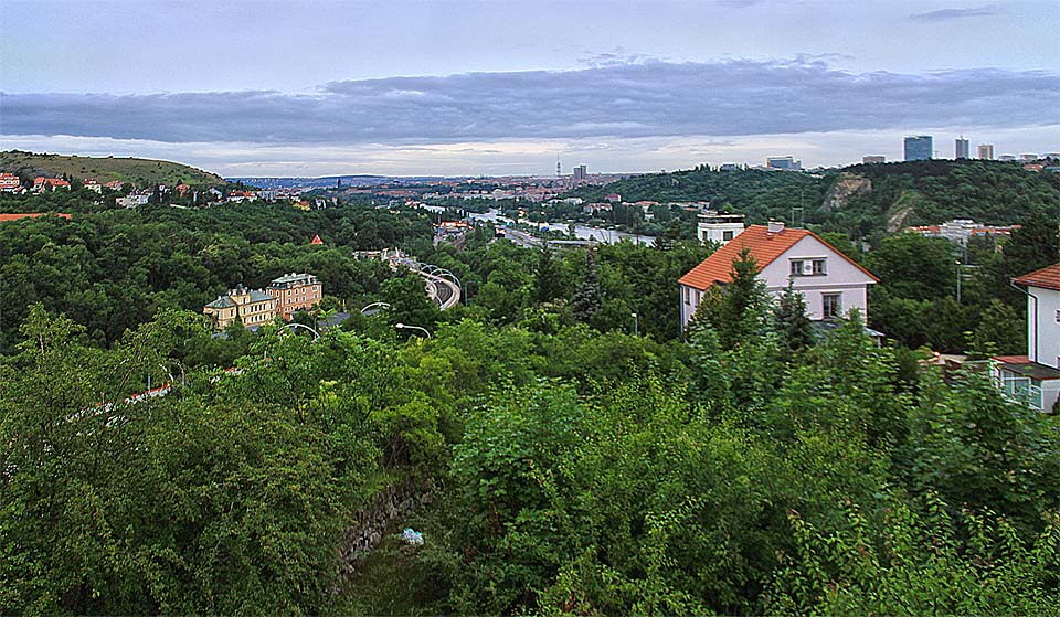 Pohled z okna vily směrem na severovýchod - k centru města na Vltavu a věž pustnoucích <a href="/Tema/Barrandovské terasy">Barrandovských teras</a> (za červenou střechou domu v popředí).