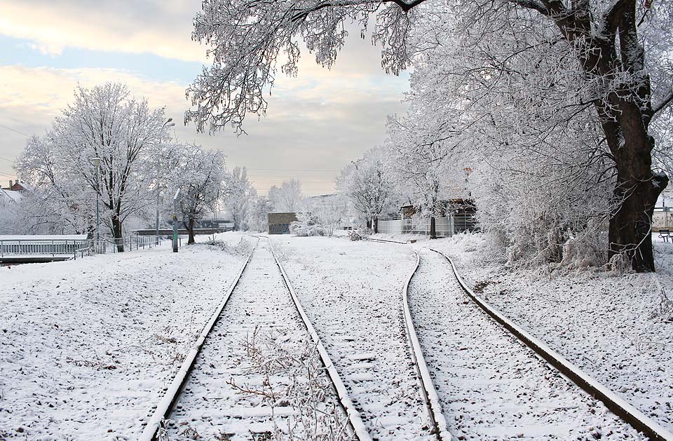 Zasněžený pohled na prostor zrušeného nákladiště Radlas od severu. Levá kolej patří <a href=/Tema/Svitavsk%C3%A1%20pob%C5%99e%C5%BEn%C3%AD%20dr%C3%A1ha>Svitavské pobřežní dráze</a>, pravá <a href=/Tema/Vle%C4%8Dka%20Svitavsk%C3%A1%20pob%C5%99e%C5%BEn%C3%AD%20dr%C3%A1ha%20-%20tepl%C3%A1rna>vlečce do teplárny</a>.