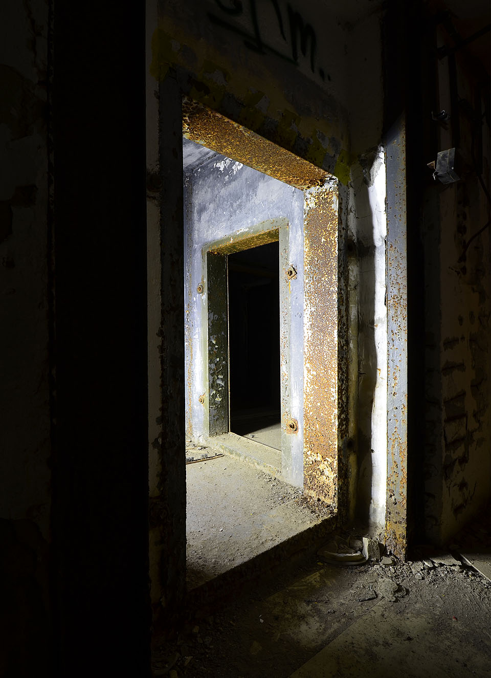 Pancéřované dveře v podzemním krytu skrývají malý labyrint chodeb v zázemí.