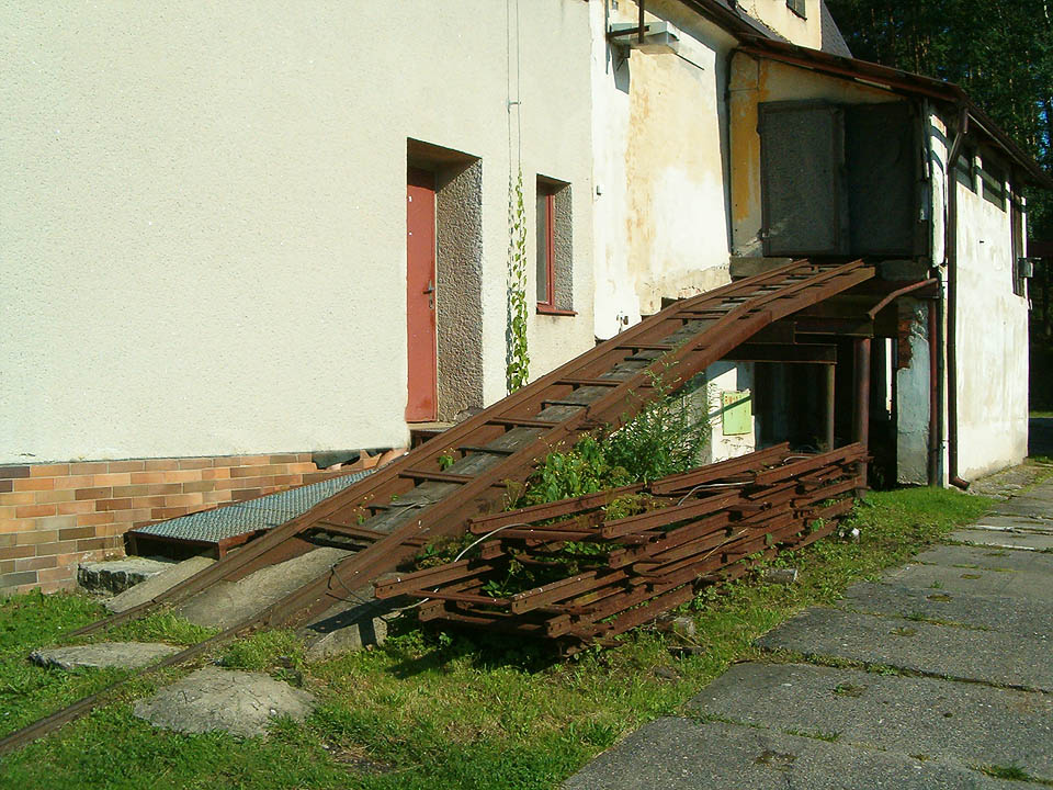 Zavážecí rampa ze zadní strany lázeňské budovy Dalibor. Těžké ocelové vozíky s rašelinou se zde zřejmě dopravují nahoru za pomoci navijáku (ten ovšem vidět není).
