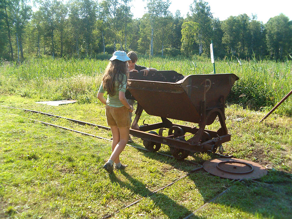 Odvážná školačka v kloboučku právě uvažuje, zda nastoupit do vozíku a nechat se povozit ledabylým hochem, který ji k tomu přemlouvá.