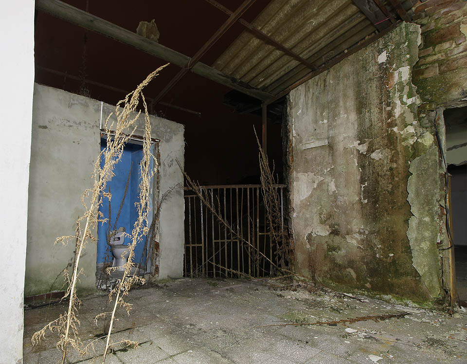 Centrem horního patra je zvláštní zákoutí na pomezí vnitřního a vnějšího prostoru, cosi mezi pavlačí, zastřešenou terasou a předsíní, ze které vybíhá přistavěná věž s toaletami a vchody do okolních bytů.