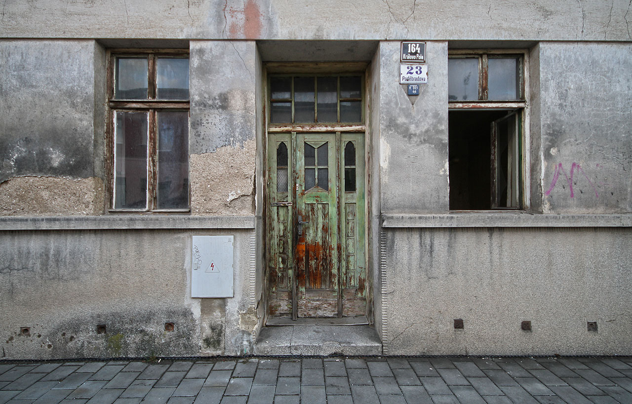 Zelené, velmi lehce secesní vstupní dveře a okno otevřené již několik týdnů dokořán.