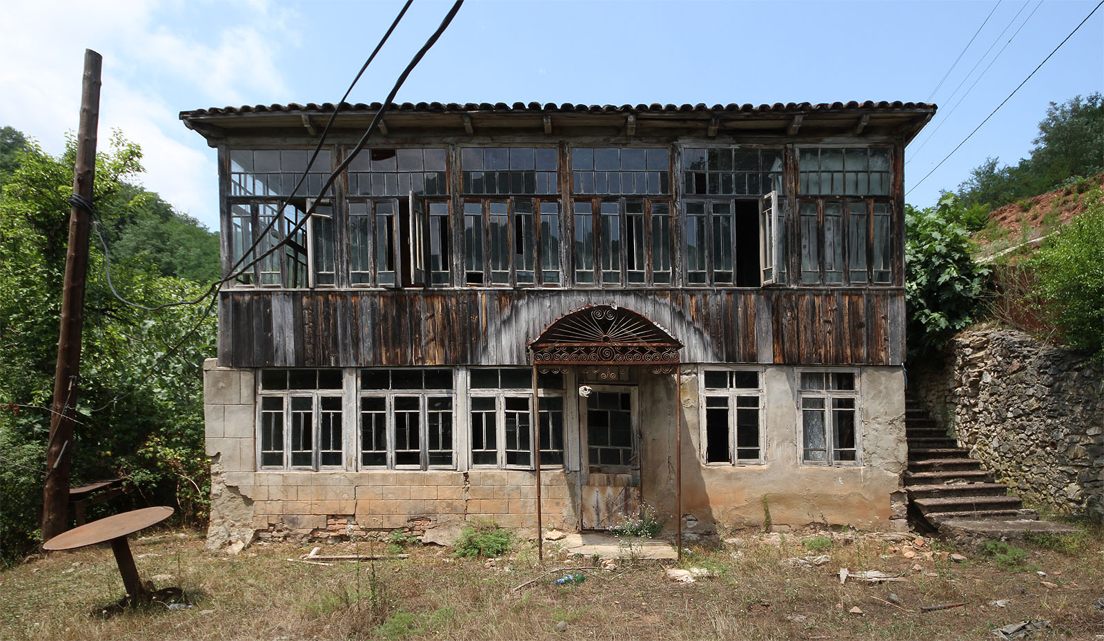 Dvouposchoďový dům disponuje útulnou dřevěnou verandou s pečlivě zasklenými a téměř nezničenými tabulkovými okny. Přestože není už řadu let obýván, je dům ve víceméně dobrém stavu. Teplo obloukovitě sálající z plechové stříšky dokonce vysouší zavlhlá prkna verandy.