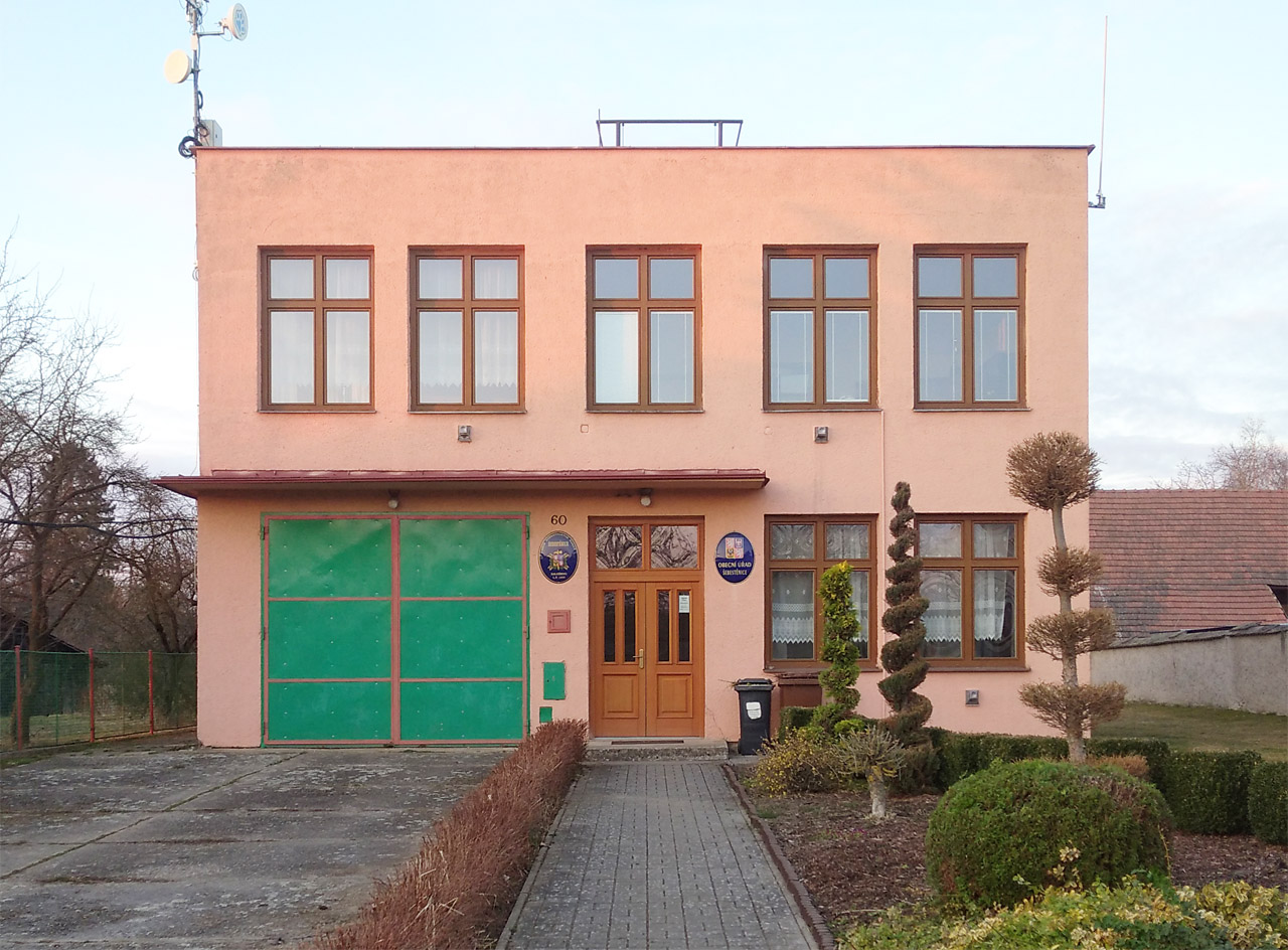 Zařadit stylově obecní úřad v Šebestenicích není jednoduché. Tvarově čistá budova je lemována pečlivě udržovanou zahrádkou okrasných dřevin.