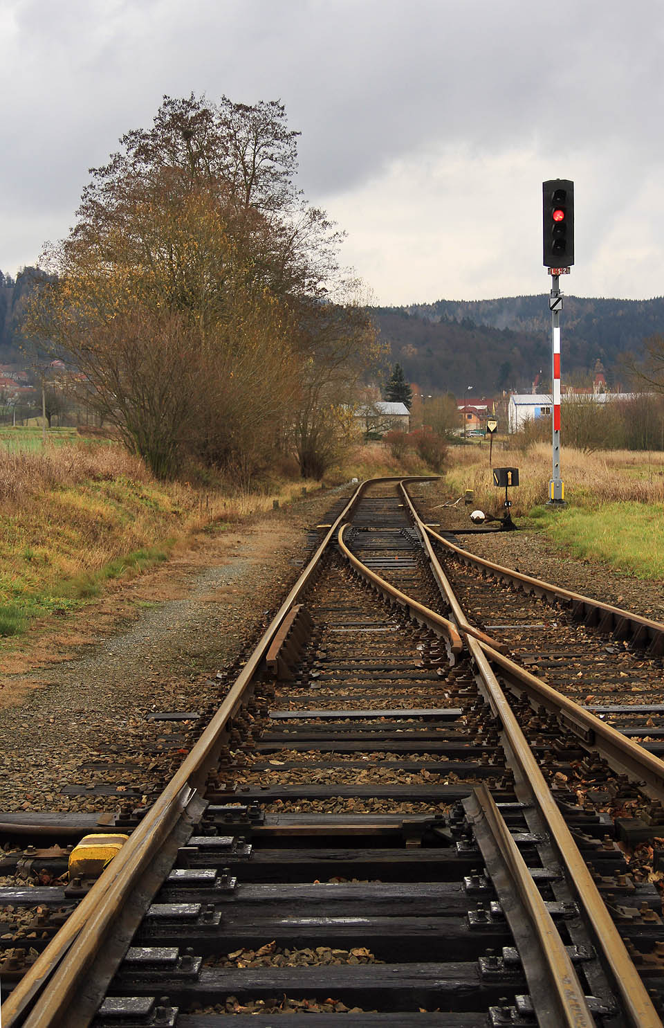 Pohled na jížní zhlaví stanice Šebetov. Nádraží se nachází na kopci a uprostřed esovitého dvojoblouku, pročež se ze stanice vždy vyjíždí směrem doprava. V dálce je vidět hala <a href=>dřevařských závodů</a> na místě, kde odbočuje z koleje <a href=/Tema/Vle%C4%8Dka%20%C5%A0ebetov%20-%20d%C5%99eva%C5%99sk%C3%A9%20z%C3%A1vody>vlečka</a>.