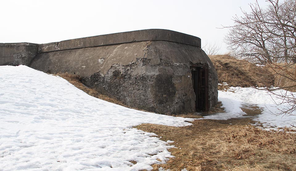 Charakteristická betonová stavba, jež sloužila současně jako opevněný sklad střeliva, který byl schopen přetrvat bez exploze i po zásahu z děla, a základ pro otočný kanón.