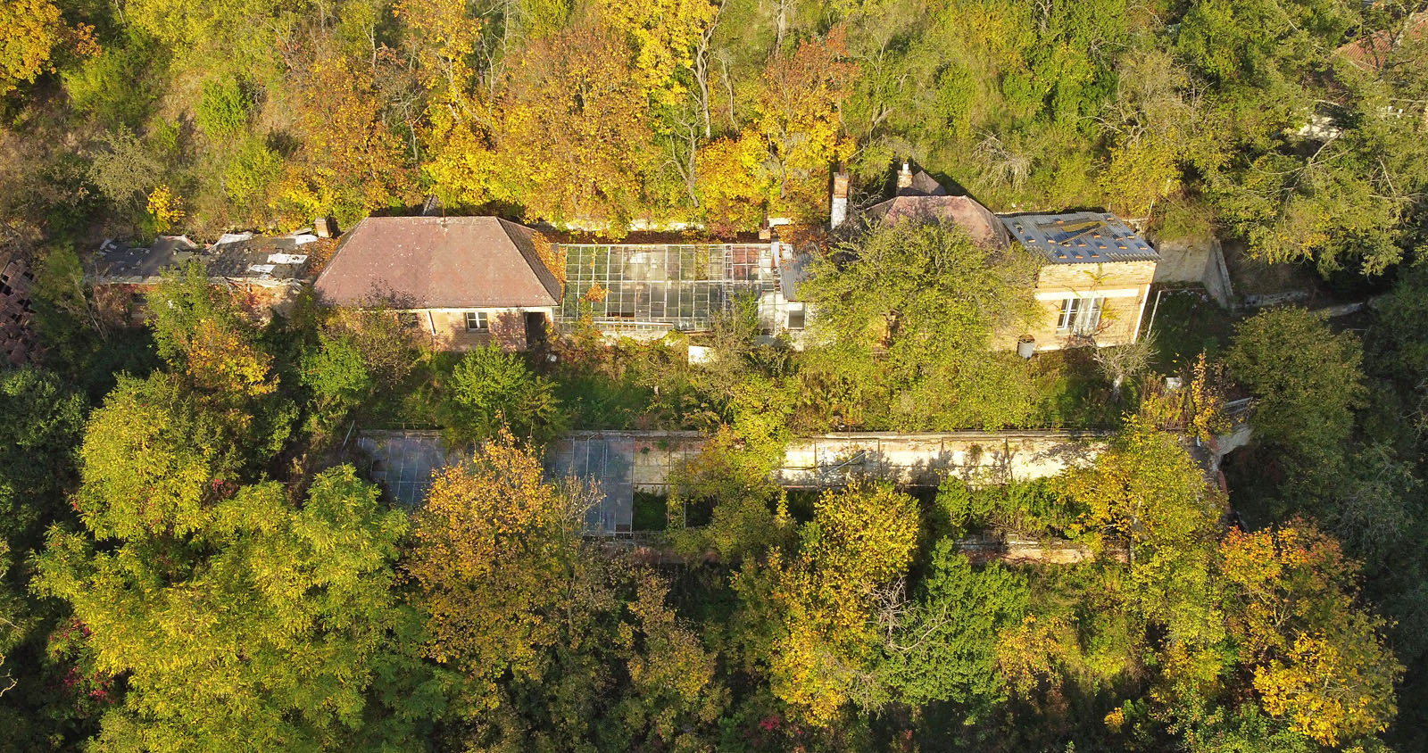 Zleva shora chlévy, hospodářská budova (zřejmě dílna a sklad), horní skleník, obytná budova s přístavbou (později možná jen zázemí zahradnictví), dole na poloviny rozdělený dolní skleník v dezolátním stavu.