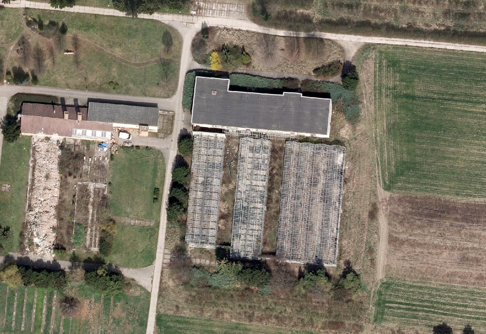 Opuštěná nová budova s učebnami a osmice skleníků, které od roku 2011 chátrají.