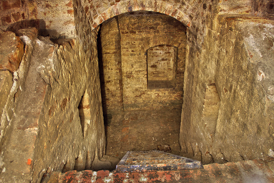 V horní části pravoúhle zalomeného schodiště lze pozorovat zbytky základů dávno zboženého domu.