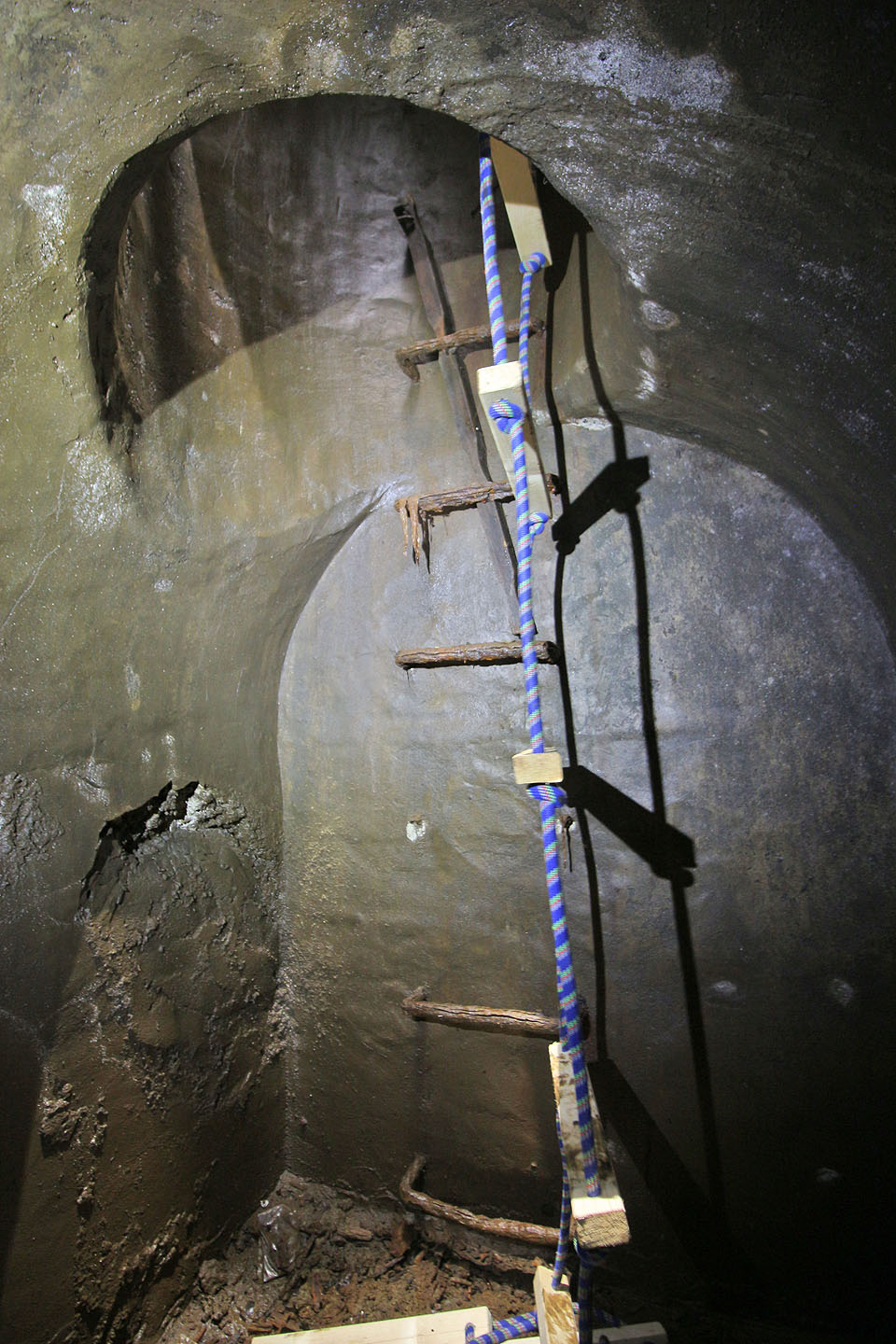 Materiál, kterým je obetonována sklepní klenba, se svým povrchem i barvou podobá nearmovanému šedivému hladkému betonu, který známe z nedaleké <a href="/Tema/Krysí štola na Špilberku">Krysí štoly</a>. Oba prostory však byly zřejmě propojeny nanjevýš kanalizačním řadem v ještě hlubších podzemních vrstvách.