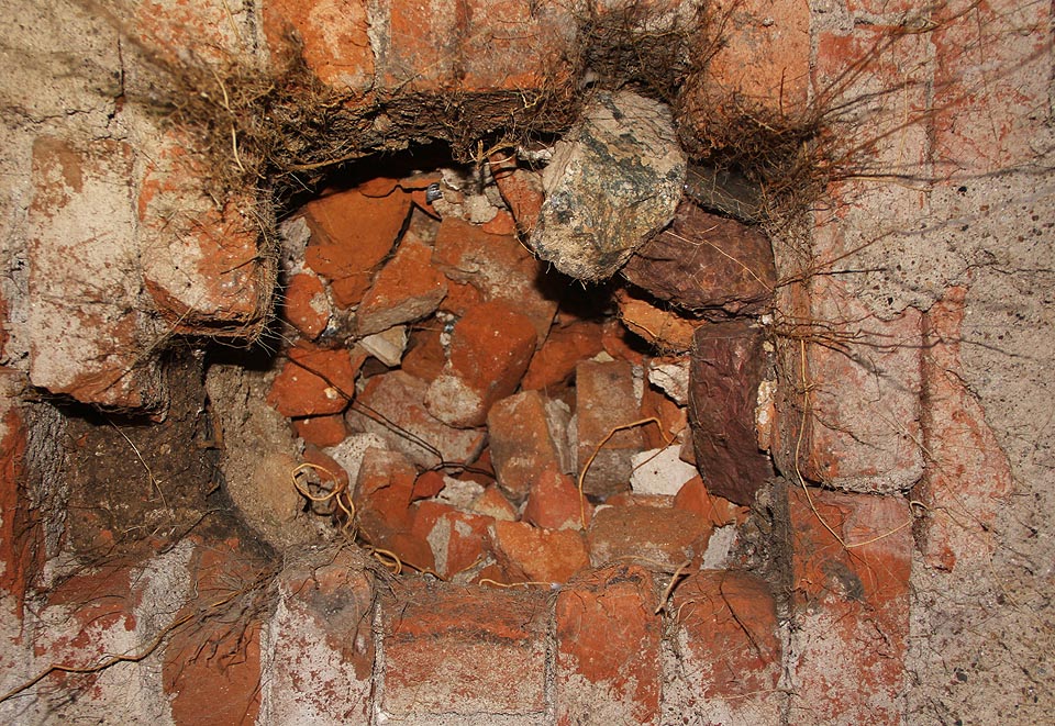 Shora ústí do klenby stropu několik čtvercových otvorů, zaspynaých cihelnou drtí. Některé kousky visí doslova na vlásku a těší se, až spadnou někomu na hlavu.