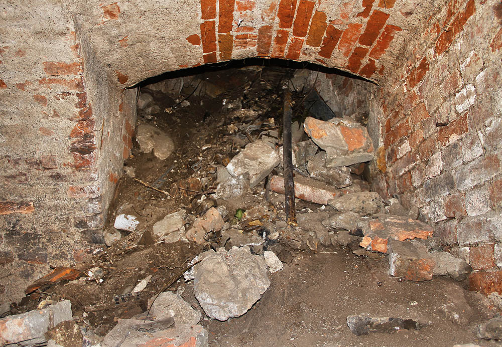 Vstup je důkladně zavalen odpadem všeho druhu, od sutě ze zbořeného domu až po komunální odpad. Přesto se lze sypkým otvorem proplazit dovnitř.