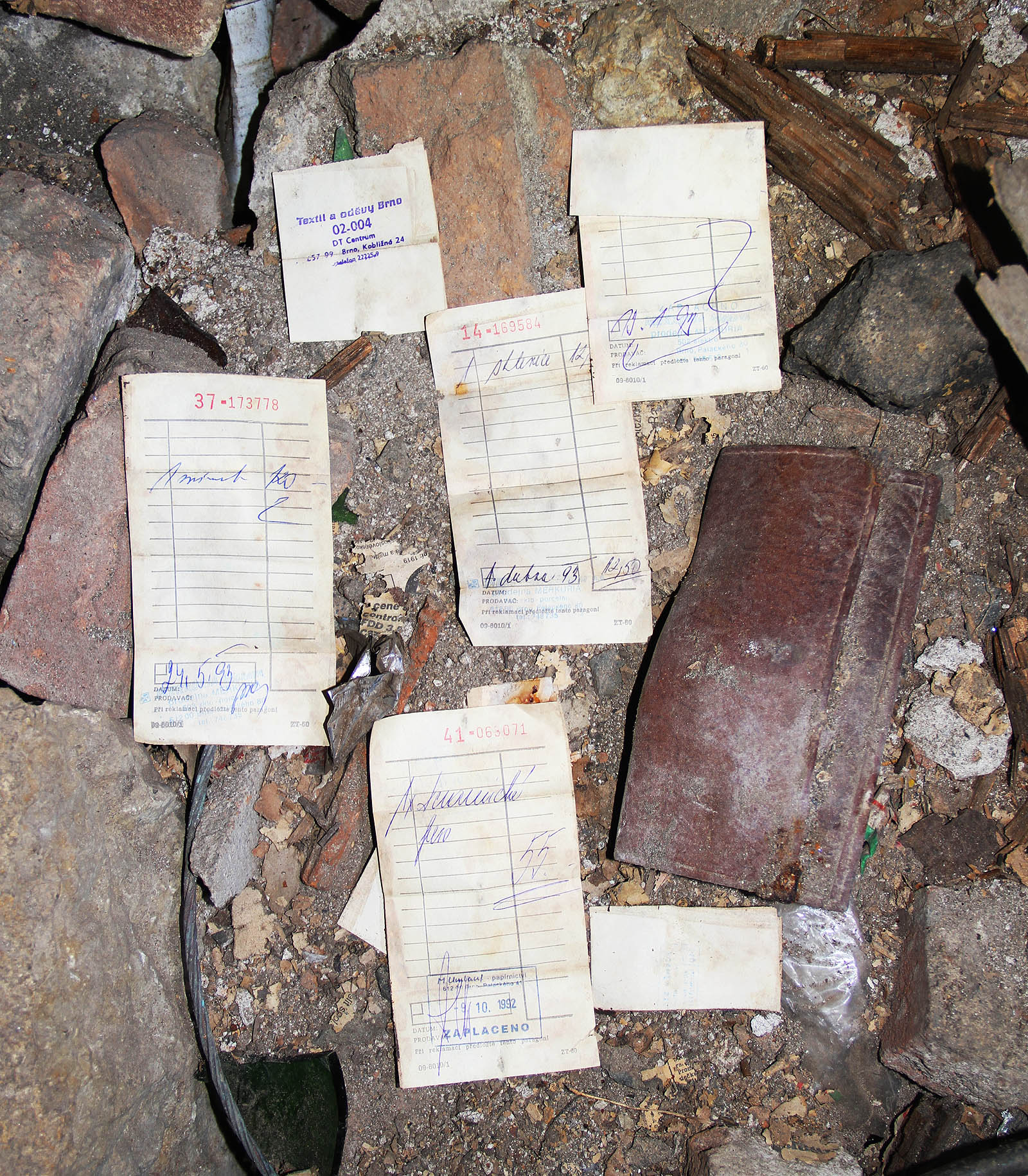 Pravděpodobně ukradená peněženka je plná dokladů za drobné nákupy z roku 1992. Vrátit majiteli jsme ji nedokázali - adresa již byla vlivem plísně dokonale nečitelná.