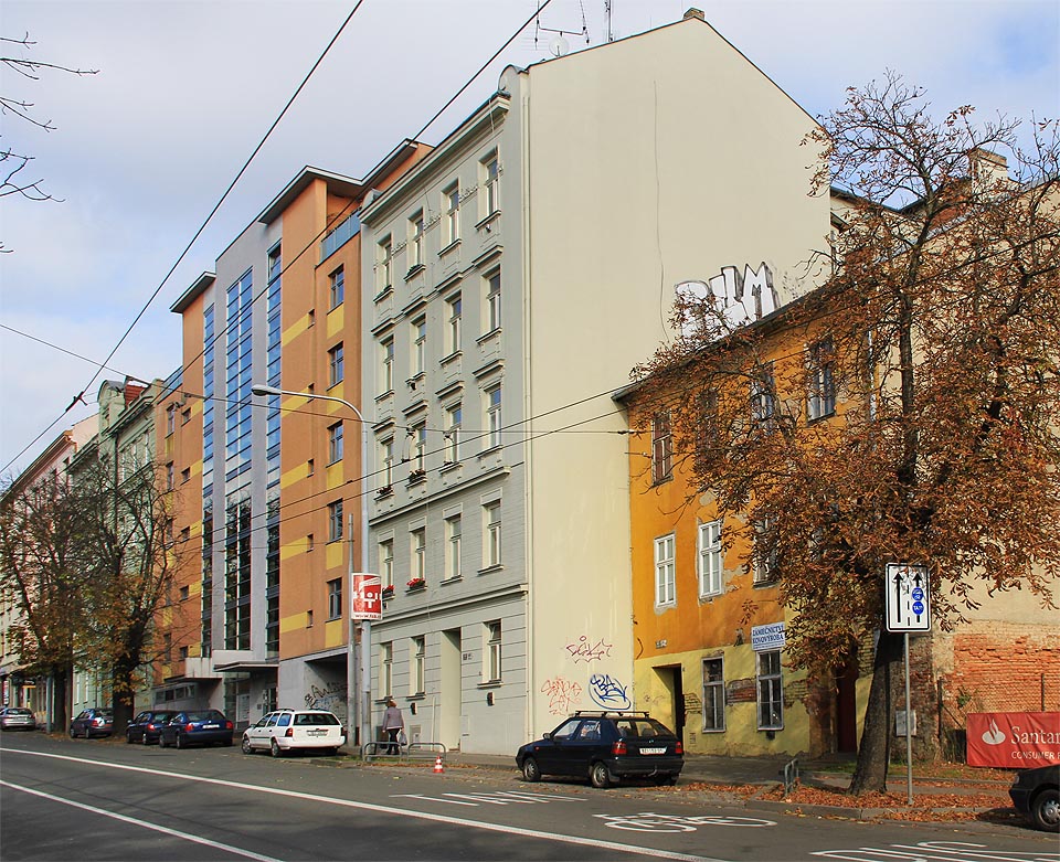 Na fotografii je dobře vidět nejvyšší moderní bytový dům Úvoz 18, stojící od roku 2007 na parcelách původních domů Úvoz 18 a Úvoz 20, které zanikly ještě před koncem 20. století. Představu o jejich originální podobě si lze snadno udělat při pohledu na poslední zachovalý původní dům na Úvoze vpředu vpravo - oranžový dům Úvoz 14. Pozn. Povšiměte si oken srovnaných s vnější plochou fasády, které jsou typickým rysem domů postavených před rokem 1850.