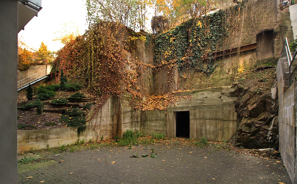 Z průchodu na dvůr vypadá vstup do zachovalé části sklepů původního domu na Úvoze 18 slibně. Po zbourání byla skalní stěna za původním dvorním traktem sanována betonovým nástřikem, vpravo nahoře je ale dobře patrný pozůstatek cihlové chodby, které možná původně rovněž pokračovala hlouběji do podzemí.