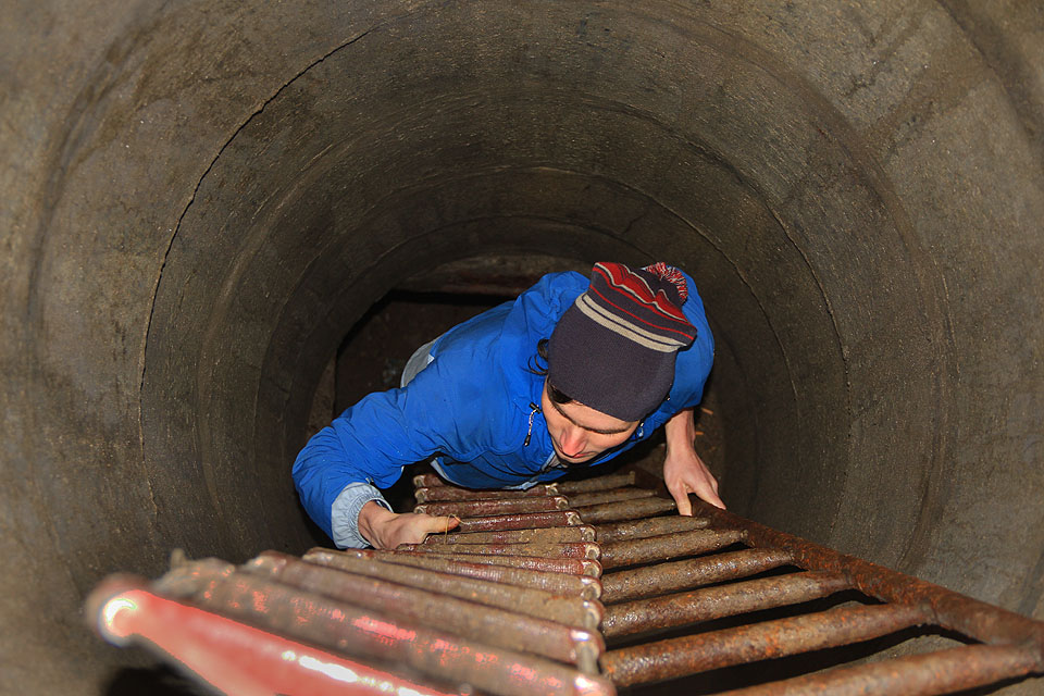 Kovový žebřík nedosahuje až k poklopu, proto je nutné opustit podzemí po provazovém.
