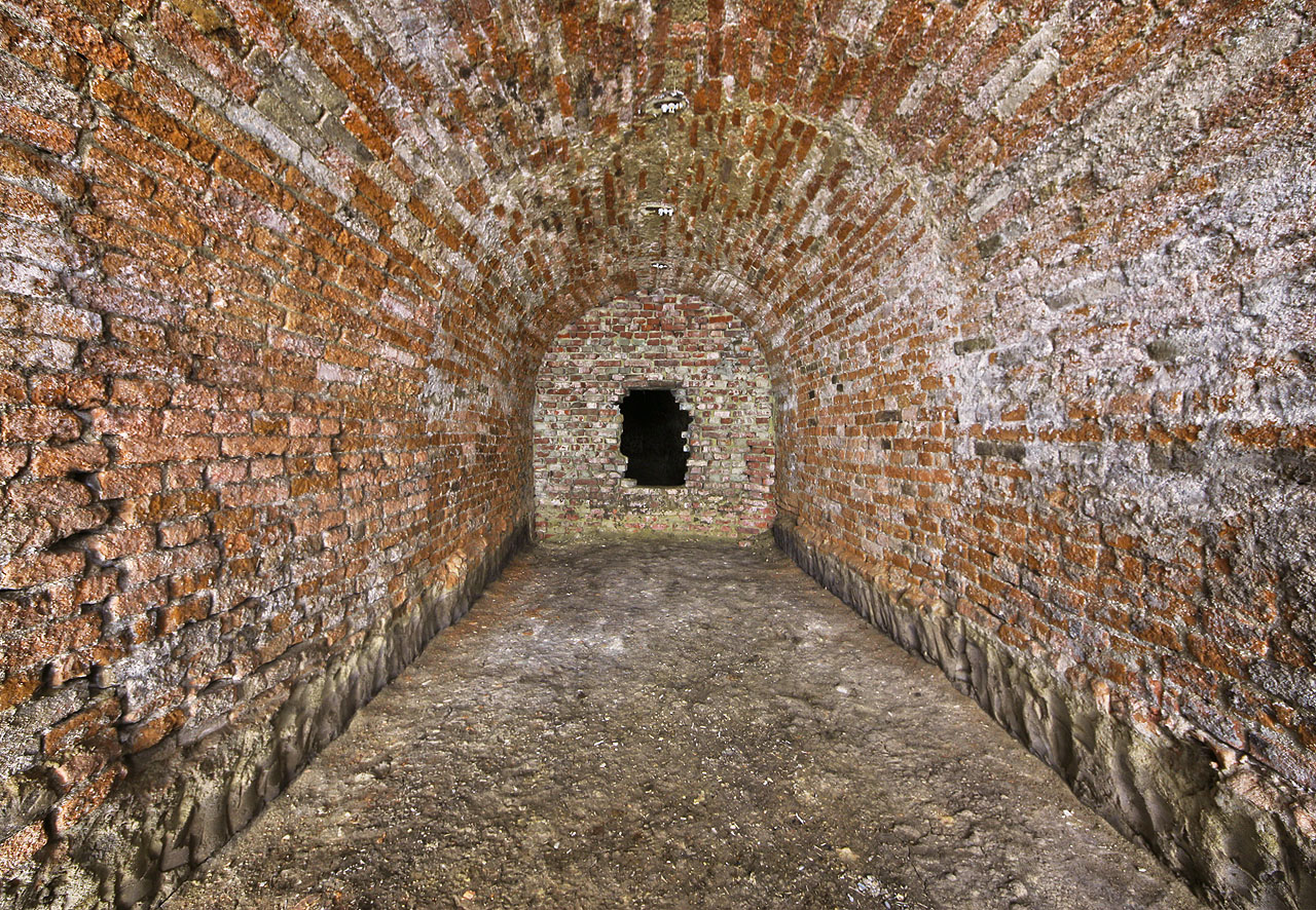 Třetí příčka pomyslného písmene T se noří hlouběji pod masiv Žlutého kopce. Chodba končí sekundární zazdívkou, za níž následuje zadní část sklepení, v průběhu 20. století připojená ke <a href="/Tema/Sklepy za domem Hlinky 62">sklepení za sousedním domem č. 62</a>.
