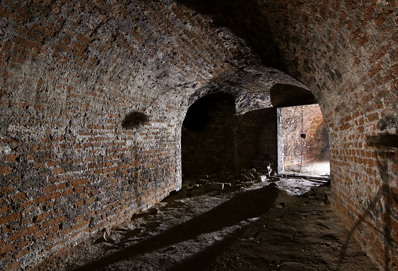 Chodba mírně zahýbá nejprve doleva a posléze zpátky doprava. Před jejím koncem odbočuje k západu další chodba, zřejmě původně spojka do sklepů za domem č. 66.