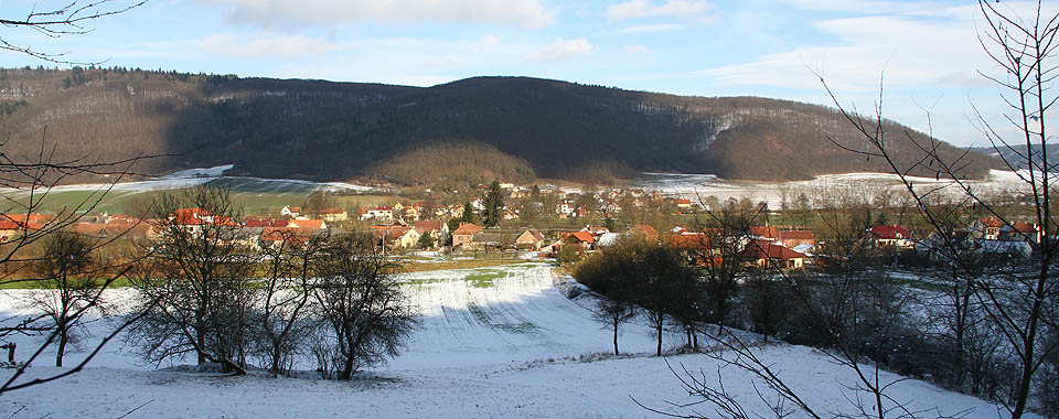 Pohled na dvě části Štěpánovic od jihozápadu z kopce Dranč. V popředí starší část obce rozvinutá po pravém břehu řeky <a href=/Tema/Svratka>Svratky</a>, ve vzdálenější části údolí novější, levobřežní část obce.