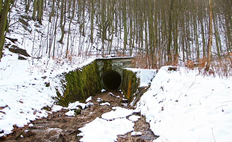 Ústí štoly Jezeří a soutok Šramnického potoka se Srnčím potokem, který přitéká betonovým korytem na pravé straně regulace.